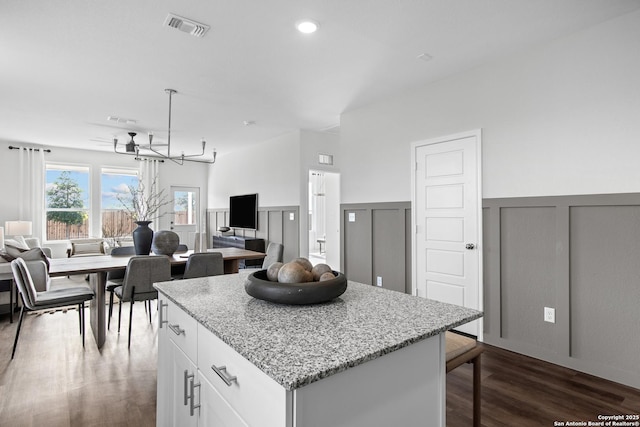 kitchen featuring dark wood finished floors, a decorative wall, visible vents, and an inviting chandelier