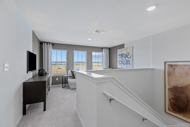 corridor featuring recessed lighting, visible vents, an upstairs landing, baseboards, and light colored carpet