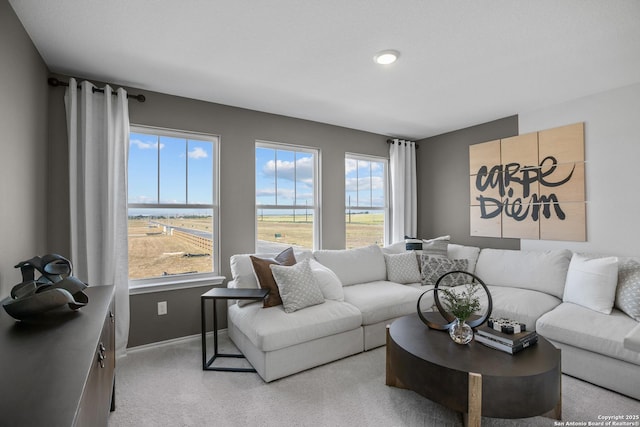 living area featuring light carpet and baseboards