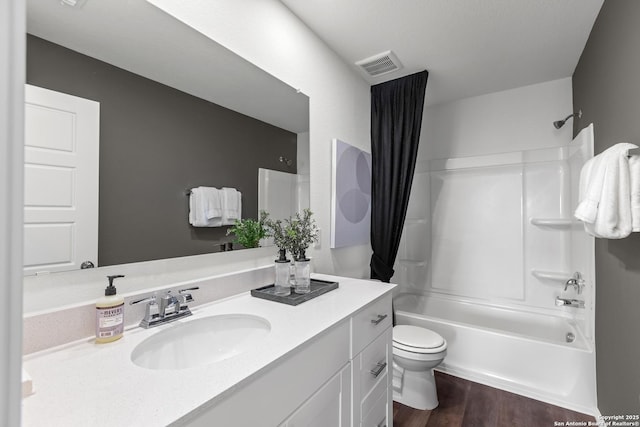 full bathroom featuring wood finished floors, vanity, toilet, visible vents, and bathing tub / shower combination