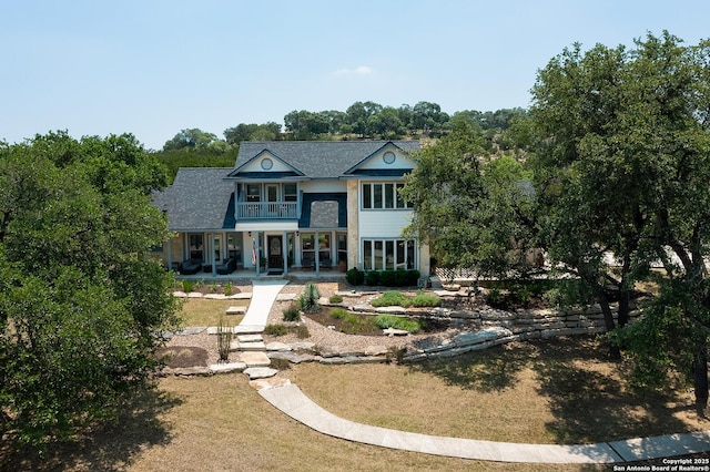 back of property with a balcony and covered porch
