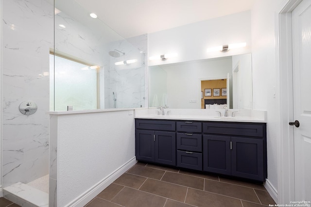 bathroom featuring double vanity, a marble finish shower, and a sink