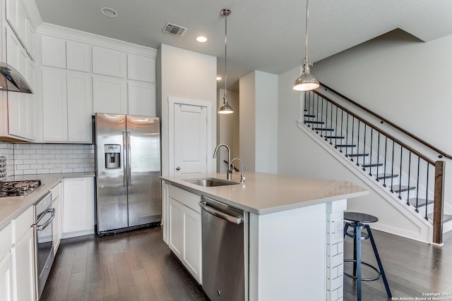 kitchen with stainless steel appliances, visible vents, a sink, and dark wood finished floors