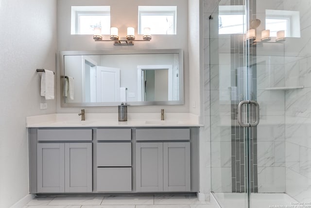 full bath featuring a sink, double vanity, and a stall shower