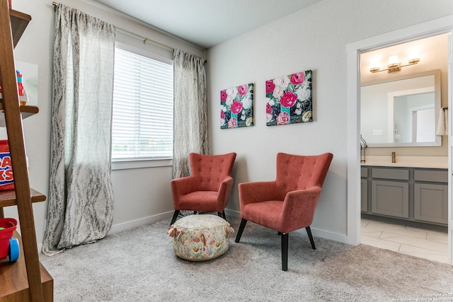 living area featuring baseboards and light colored carpet