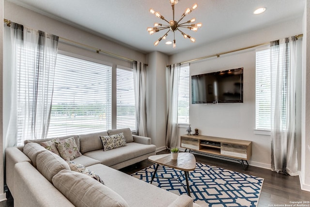 living area featuring wood finished floors, baseboards, recessed lighting, and a notable chandelier