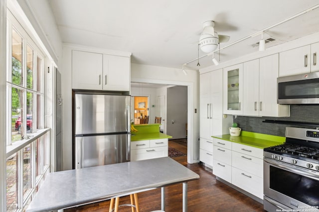 kitchen featuring white cabinets, stainless steel appliances, visible vents, and glass insert cabinets