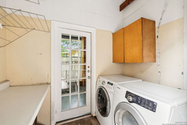 clothes washing area with washer and clothes dryer and cabinet space