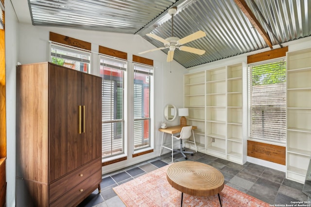 office area featuring vaulted ceiling, a healthy amount of sunlight, built in shelves, and ceiling fan