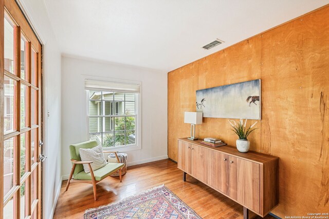 sitting room with baseboards, visible vents, and light wood-style flooring