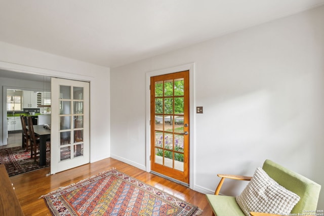 doorway to outside featuring baseboards and wood finished floors