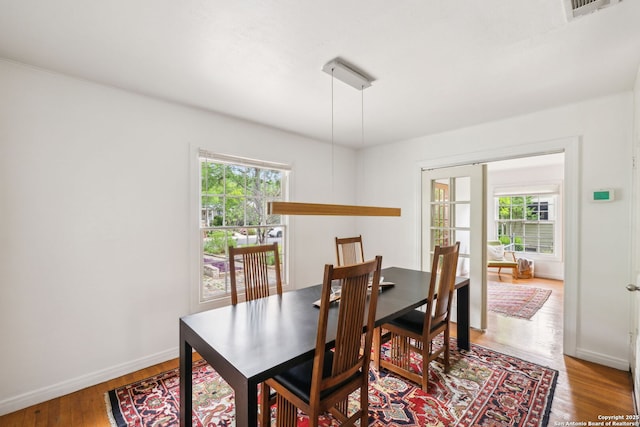 dining space featuring baseboards, wood finished floors, and plenty of natural light