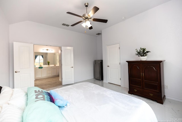 bedroom featuring ensuite bath, lofted ceiling, visible vents, and baseboards