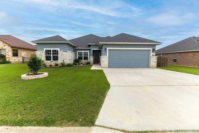 prairie-style house with stone siding, concrete driveway, fence, a garage, and a front yard