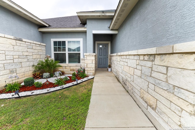 doorway to property with stone siding, fence, and a shingled roof