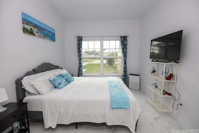 bedroom featuring marble finish floor and baseboards