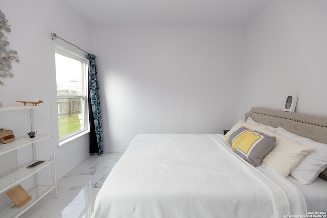 bedroom with baseboards and marble finish floor