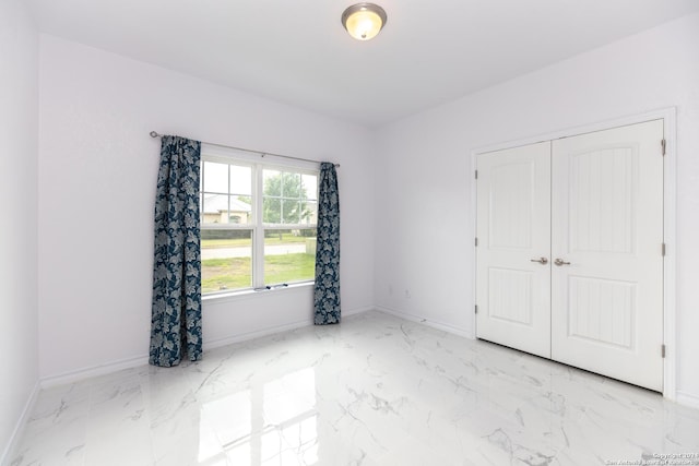 unfurnished room featuring baseboards and marble finish floor