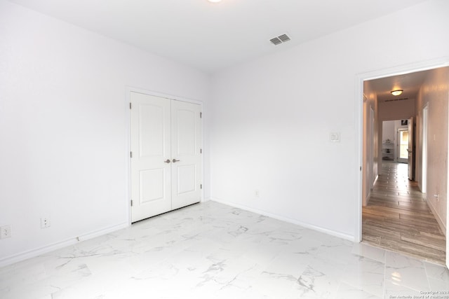 spare room featuring visible vents, marble finish floor, and baseboards
