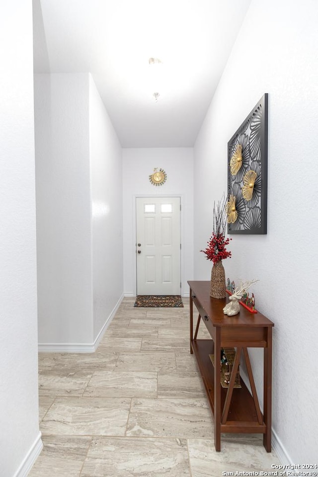 doorway to outside with light wood-style flooring and baseboards