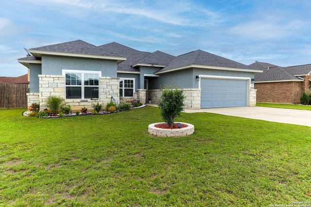 prairie-style home featuring fence, stucco siding, driveway, a front yard, and a garage