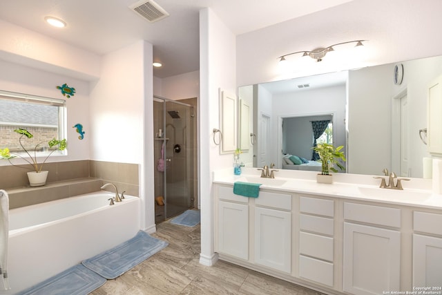 full bathroom featuring a sink, double vanity, a stall shower, ensuite bathroom, and visible vents