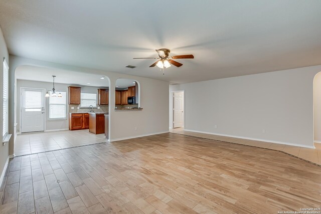 342 Perch Horizon, San Antonio, TX 78253 - unfurnished living room featuring arched walkways, light wood-style floors, visible vents, and ceiling fan with notable chandelier