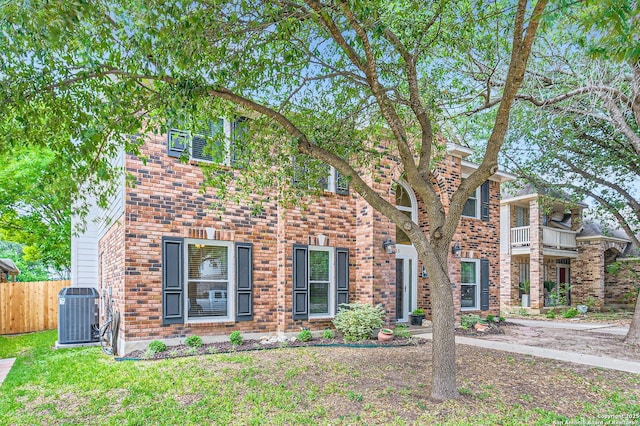view of front of property featuring central air condition unit, fence, and brick siding