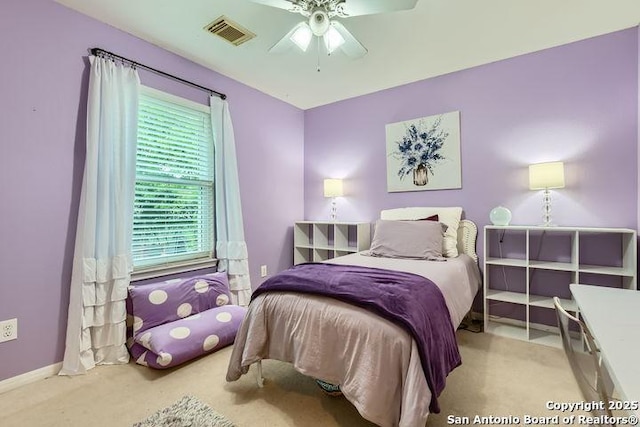 carpeted bedroom featuring baseboards, a ceiling fan, and visible vents