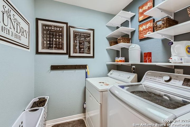 clothes washing area with laundry area, washing machine and dryer, and baseboards