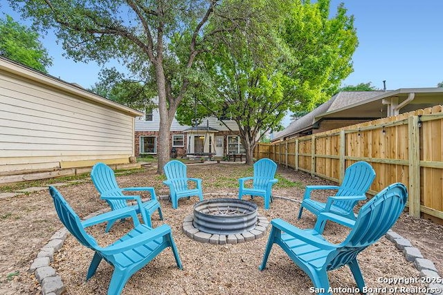 view of yard with fence and an outdoor fire pit