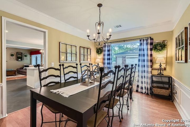 dining room featuring visible vents, plenty of natural light, wood finished floors, and a notable chandelier