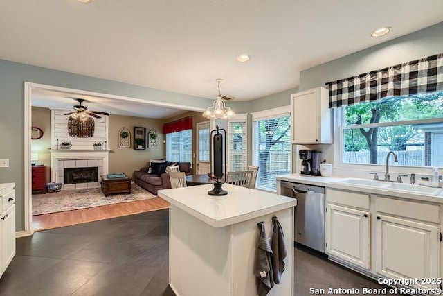 kitchen with a sink, dishwasher, white cabinets, and light countertops