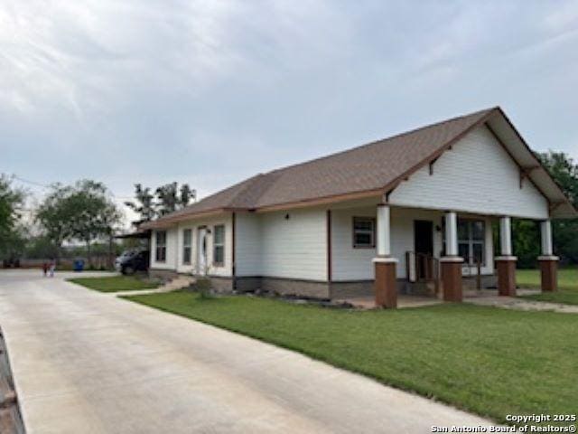1121 N Oak, Pearsall, TX 78061 - view of front of home with a porch, a front yard, and concrete driveway