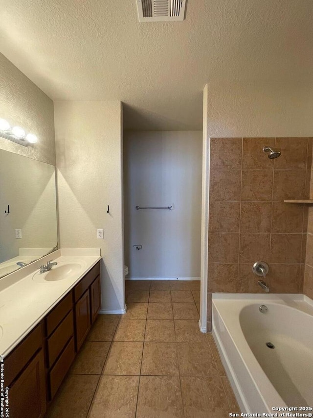 bathroom with a textured ceiling, vanity, baseboards, tile patterned flooring, and visible vents