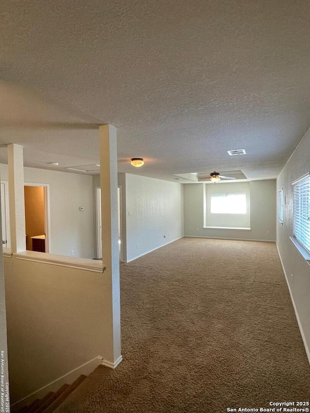 below grade area with carpet floors, a textured ceiling, and baseboards