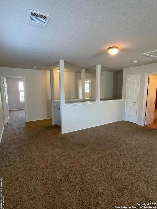 interior space with baseboards, visible vents, carpet floors, and a textured ceiling