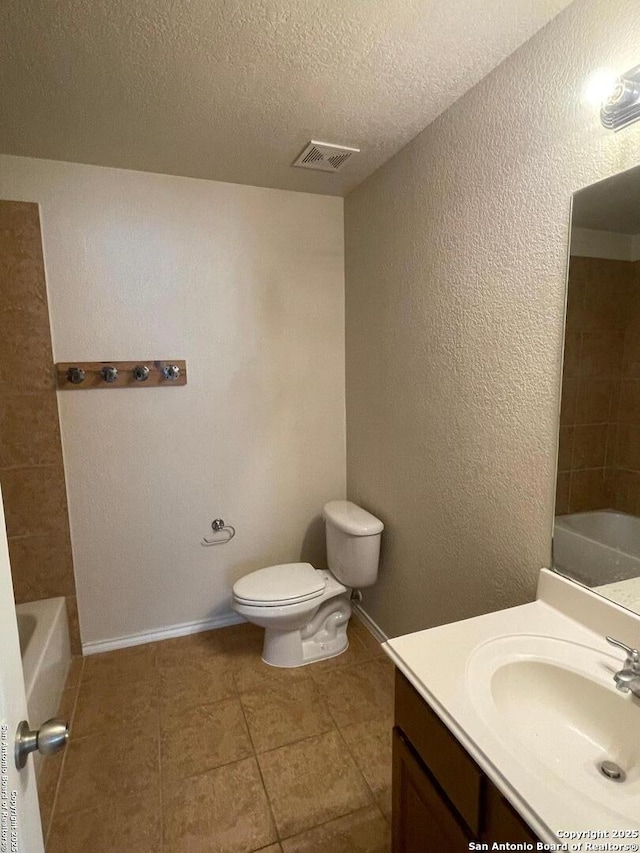bathroom with tile patterned flooring, visible vents, toilet, vanity, and a bathing tub