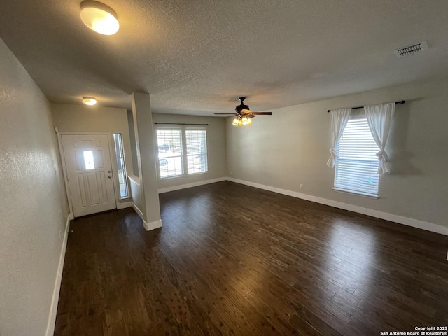 foyer entrance featuring dark wood-style floors, a textured ceiling, baseboards, visible vents, and ceiling fan