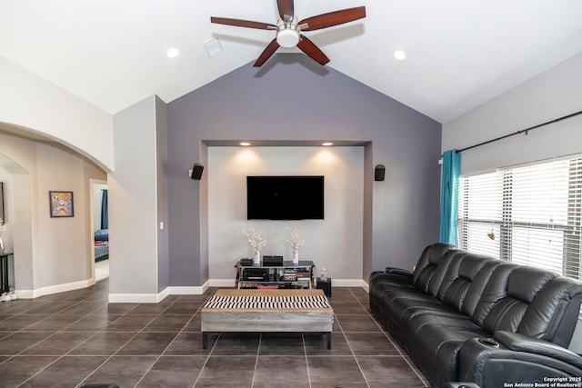 tiled living area with high vaulted ceiling, arched walkways, a ceiling fan, and baseboards