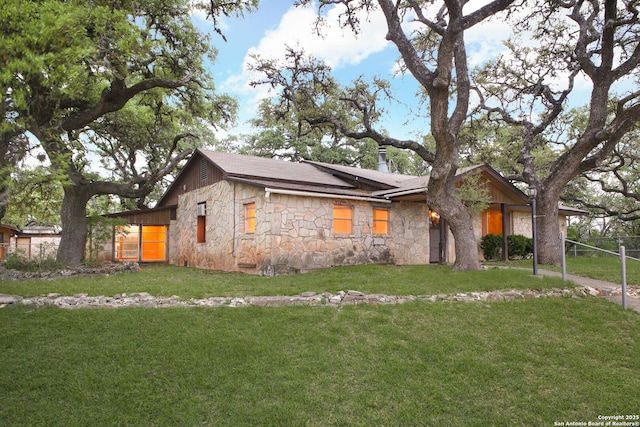 ranch-style home featuring stone siding and a front yard