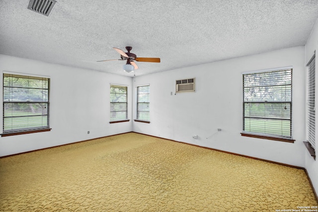 spare room with ceiling fan, light carpet, a textured ceiling, and visible vents