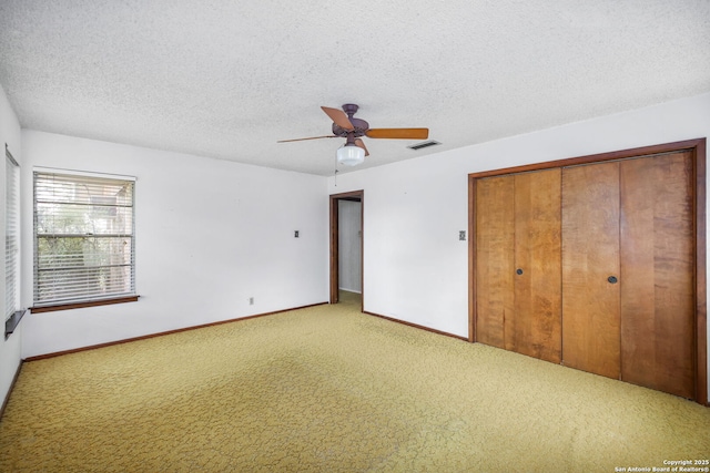 unfurnished bedroom with visible vents, light carpet, a closet, baseboards, and a textured ceiling