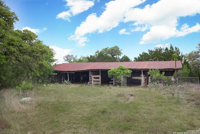 back of house with an outdoor structure and metal roof