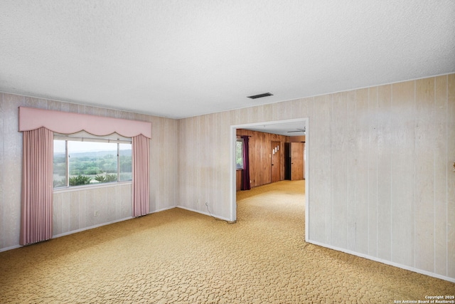 carpeted empty room featuring visible vents and a textured ceiling