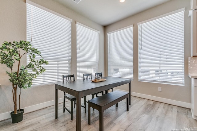 dining area with light wood finished floors and baseboards