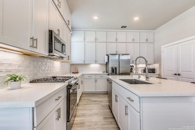 kitchen with visible vents, a sink, white cabinetry, and appliances with stainless steel finishes