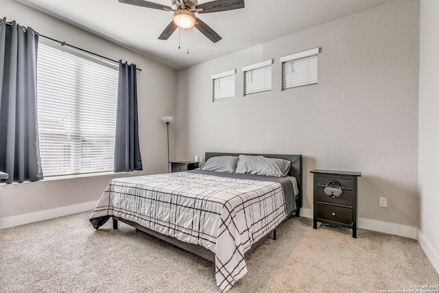 bedroom featuring ceiling fan, baseboards, and light colored carpet