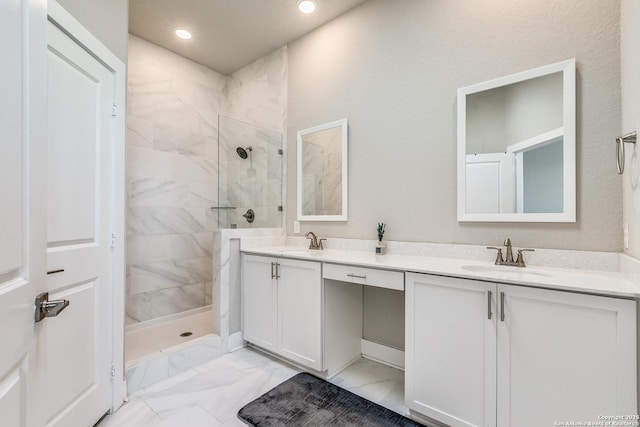 full bath with marble finish floor, a sink, a walk in shower, and double vanity