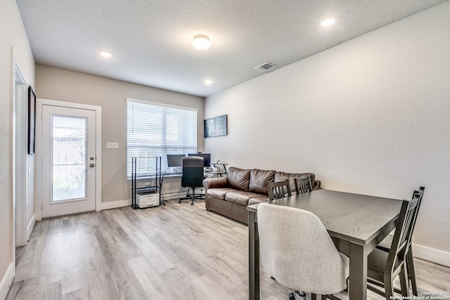 living room with recessed lighting, visible vents, light wood finished floors, and baseboards
